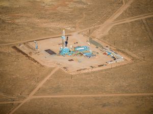 (Trent Nelson  |  The Salt Lake Tribune) A drill rig rises above wells under development in the Uinta Basin east of Vernal on Nov. 17, 2021, as drilling activity picks up in the face of rising oil and gas prices. A new audit says Utah's Office of Energy Development is not adequately planning for Utah's energy future. This photograph was taken on a flight chartered by LightHawk.