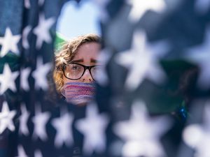 (Andrew Harnik | AP file photo) Emma Rousseau of Oakland, N.J., her mouth bound with a red, white and blue netting, attends a rally on the Fourth of July to protest for abortion rights, at Lafayette Park in front of the White House in Washington, Monday, July 4, 2022. One year ago, the U.S. Supreme Court rescinded a five-decade-old right to abortion, prompting a seismic shift in debates about politics, values, freedom and fairness.