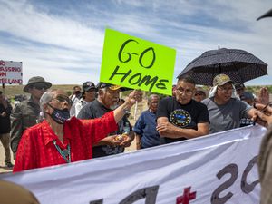 (Jon Austria | The Albuquerque Journal via AP) Landowner Paulina Atenico, left, tell activists to "go home" near a road block on County Road 7950 east of Chaco Culture National Park on Sunday, June 11, 2023. Opponents and supporters for a buffer zone around Chaco Culture National Park clashed on Sunday after Navajo Allotees blocked a portion of CR 7950 that lead in to the park during U.S. Interior Secretary Deb Haaland's planed visit.