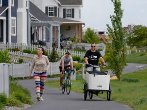 (Francisco Kjolseth | The Salt Lake Tribune) Chris Wiltsie, center, of Bike Utah, and his son Soren, 3, join Mike West, a Daybreak resident, as he pedals his cargo bike along the Oquirrh Lake Loop Trail in his neighborhood during a bicycle tour of the area on Thursday, May 25, 2023.