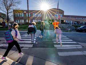 (Francisco Kjolseth  | The Salt Lake Tribune) Crossing guard Bing Kerwood helps students cross the street safely at Bonneville Elementary on Tuesday, April 20, 2021.