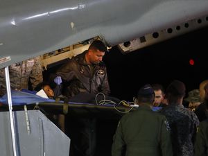 Military personnel  at the air base in Bogota, Colombia, on Saturday unload from a plane one of four children who were missing after a deadly plane crash. The children survived a small plane crash 40 days ago and had been the subject of an intense search in the jungle. (AP Photo/John Vizcaino)